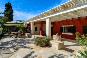 a house with a patio with a table and an umbrella at La Vila Ibiza in Sant Josep de sa Talaia