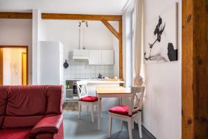 a living room with a table and a kitchen at Ferienwohnung Ebbe am Weserstrand in Sandstedt