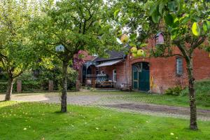 a brick house with trees in front of it at Ferienwohnung Ebbe am Weserstrand in Sandstedt