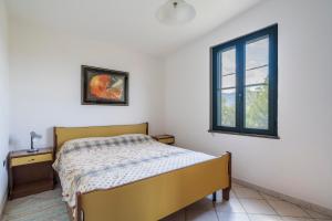 a bedroom with a bed and a window at Su entu a mari Museddu in Cardedu