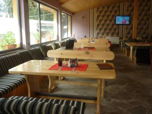 uma fila de mesas de madeira num restaurante em Apartments Black Horse em Pamporovo
