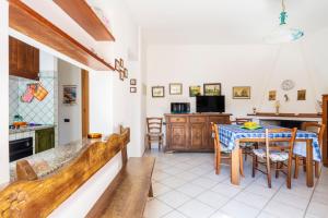 a kitchen and dining room with a table and chairs at Su entu a mari Museddu in Cardedu