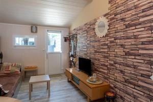 a living room with a brick wall at Appart Aux portes de la Camargue in Manduel