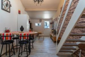 a dining room with a table and chairs and a brick wall at Appart Aux portes de la Camargue in Manduel