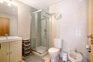 a bathroom with a shower and a toilet and a sink at Apartamento Maré Cheia Sl40 in Santa Luzia +20 photos