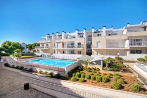 an apartment building with a swimming pool in front of it at Apartamento Maré Cheia Sl40 in Santa Luzia