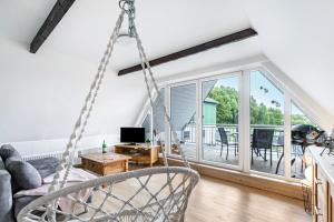 a swing in a living room with a balcony at Ferienwohnung Carolin Witt in Großsolt