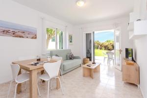 a living room with a table and a couch at Biniforcat 21 in Cala en Forcat