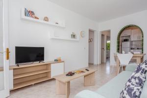 a living room with a couch and a tv at Biniforcat 21 in Cala en Forcat