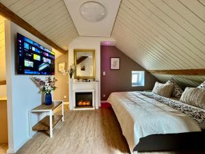 a bedroom with a bed with a fireplace and a tv at Lot54 Holiday Homes in Feuerscheid +120 photos