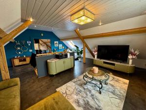 a living room with a tv and a couch and a table at Lot54 Holiday Homes in Feuerscheid