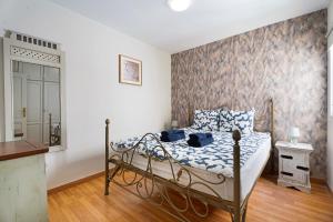 a bedroom with a bed with blue and white sheets at Nido Andrea in San Isidro