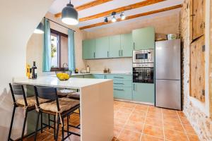 a kitchen with mint green cabinets and a refrigerator at Mas de Morera in Vall dʼAlba