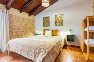 a bedroom with a bed and a brick wall at Mas de Morera in Vall dʼAlba +25 photos