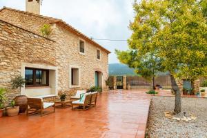 an outdoor patio with chairs and a building at Mas de Morera in Vall dʼAlba