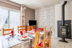 a dining room with a table and a fireplace at Gite Augustine Aux Charmes D'antan in Sevremont