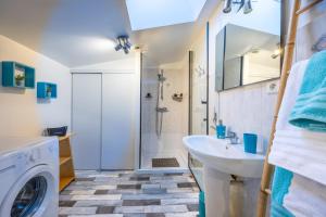 a bathroom with a washing machine and a sink at Gite Augustine Aux Charmes D'antan in Sevremont +29 photos
