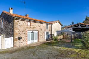 a stone house with a gate and a fence at Gite Augustine Aux Charmes D'antan in Sevremont