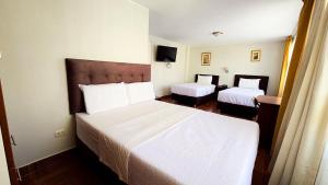 a hotel room with two beds in a room at Hotel Palmeras Tacna in Tacna