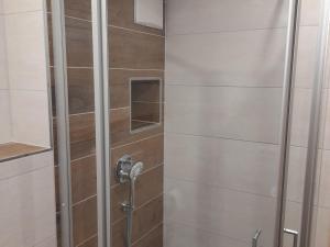 a shower with a glass door with a faucet at Geigerbauernhof in Mühlenbach +22 photos