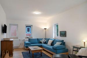 a living room with a blue couch and a table at Sand 68 in Steinau an der Straße