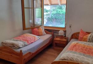 a bedroom with two beds and a window at Geigerbauernhof in Mühlenbach