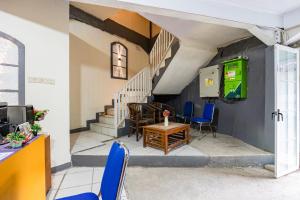 a room with blue chairs and a table and stairs at Simple Hotel Bogor RedPartner in Bogor