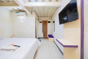 a room with two beds and a flat screen tv at Simple Hotel Bogor RedPartner in Bogor +20 photos