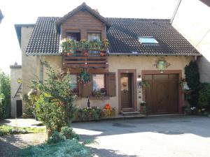 a house with a balcony with flowers on it at Le Gite Fleuri in Hazelbourg