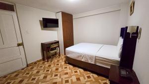 a bedroom with a bed and a television in it at Hotel Palmeras Tacna in Tacna