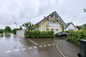 a house with a car parked in a parking lot at Sonnige Ferienwohnung mit Balkon in Küssaberg