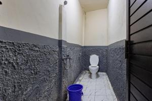 a bathroom with a toilet and a trash can at Simple Hotel Bogor RedPartner in Bogor