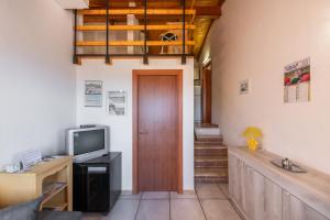 a room with a door and a television and stairs at Villa Birgit in Monte Nai