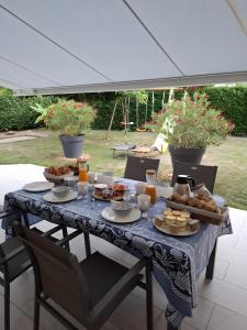 a table with a blue table cloth with food on it at Chambre D'hôte - La Capucine in Bazouges
