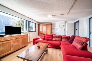 a living room with a red couch and a tv at Chalet Châtel - calme et spacieux in Châtel