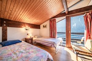 a bedroom with two beds and a large window at Chalet Châtel - calme et spacieux in Châtel