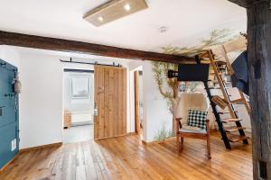 a living room with a ladder and a chair at Stub'n Ludwig in Waischenfeld