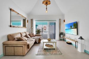 a living room with a couch and a table at Orange Light with private pool in Corralejo