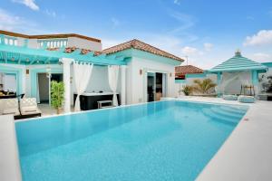 a swimming pool in front of a villa at Orange Light with private pool in Corralejo