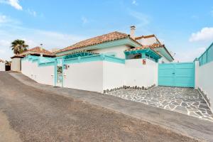 a house with a white and blue garage at Orange Light with private pool in Corralejo