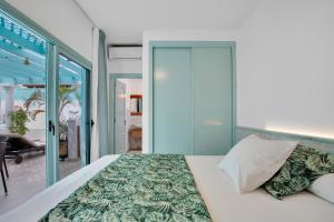a bedroom with a bed with a glass door at Orange Light with private pool in Corralejo +37 photos