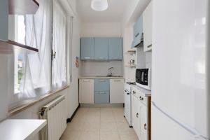 a small kitchen with white cabinets and a sink at Porta Delle 5 Terre in Levanto +20 photos
