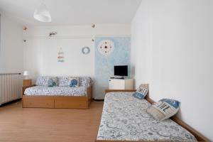 a bedroom with two beds and a tv at Porta Delle 5 Terre in Levanto
