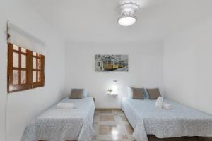two beds in a room with white walls at Casa Zoiben in San Nicolás