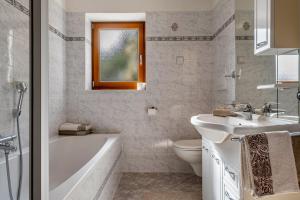 a bathroom with a tub and a sink and a toilet at Malsötscherhof Apt B in Villandro +27 photos