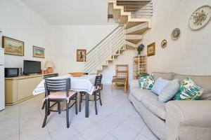 a living room with a couch and a table and chairs at Villa Liberty Rosa 1912 in San Vincenzo