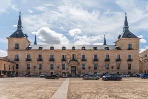 a large building with cars parked in front of it at El Palomar De La Cuesta in Lerma