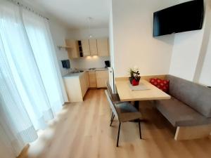 a living room with a table and a couch at Fröhlichhof Wohnung Apfelblüte in Lagundo