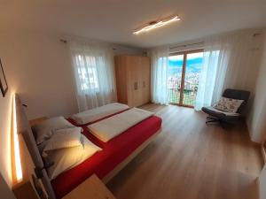 a bedroom with a large bed and a large window at Fröhlichhof Wohnung Apfelblüte in Lagundo