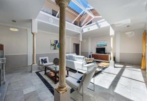 a living room with a pillar and a table and chairs at Villa Domus Vesta in Marbella
